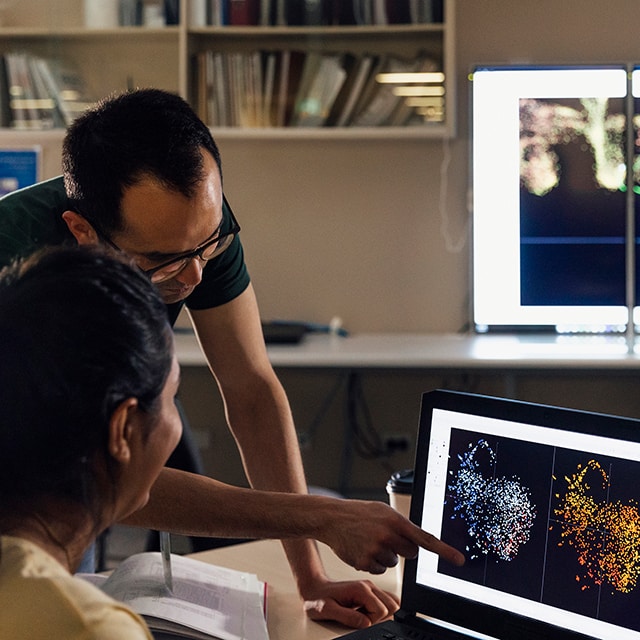 Researcher pointing to monitor in lab environment